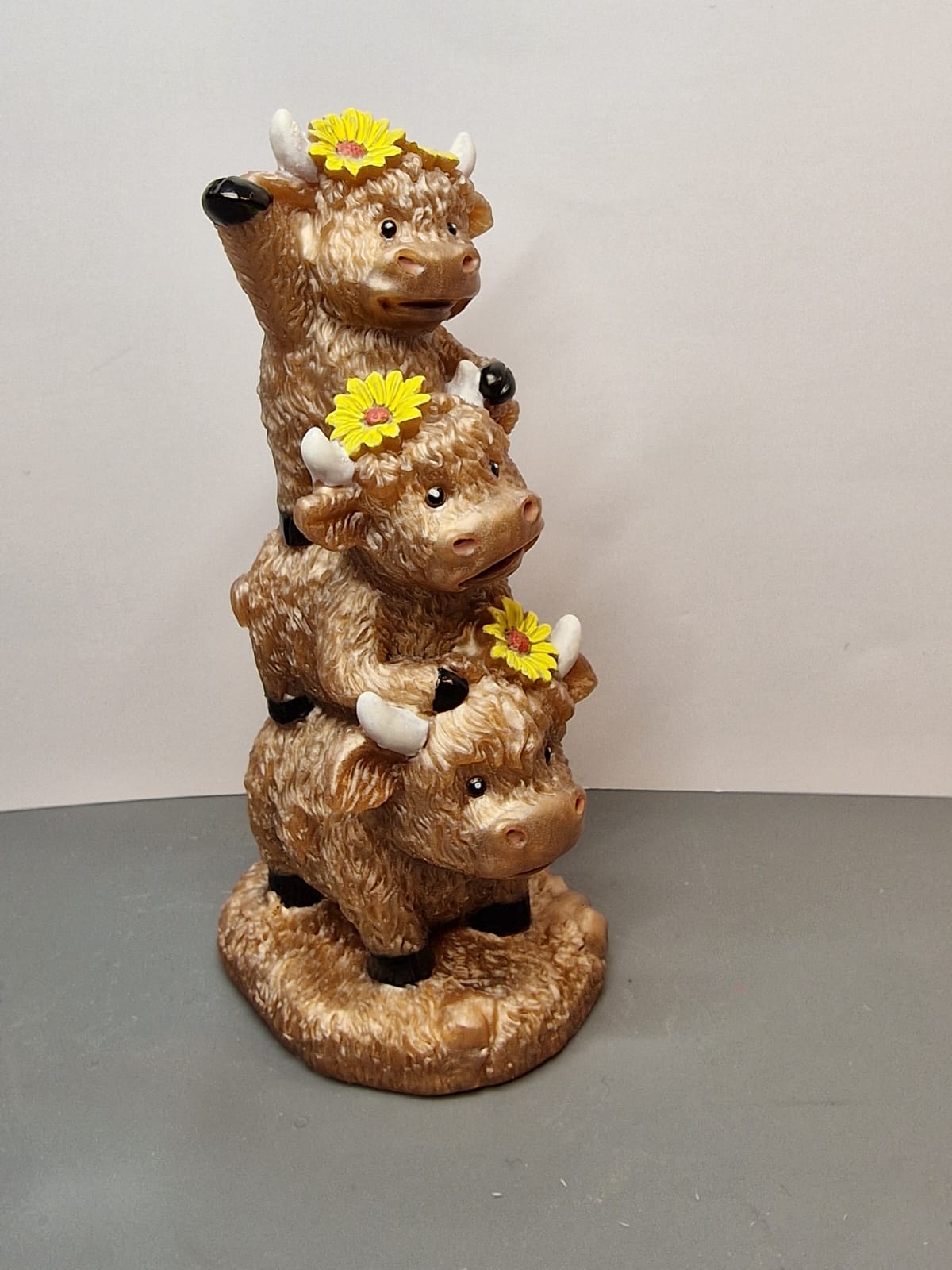 Stacked highland cows with yellow flowers