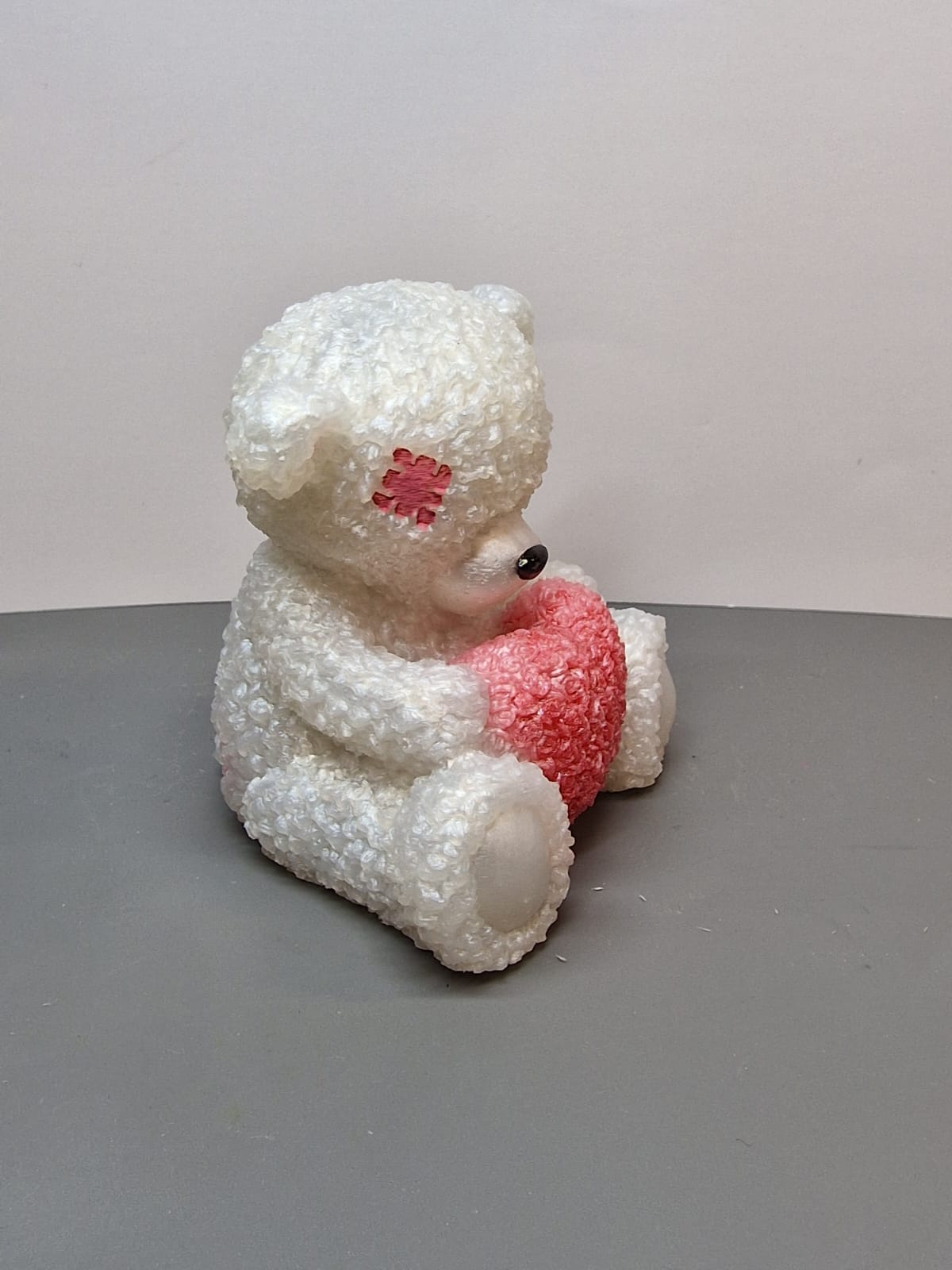 White teddy bear with heart side view